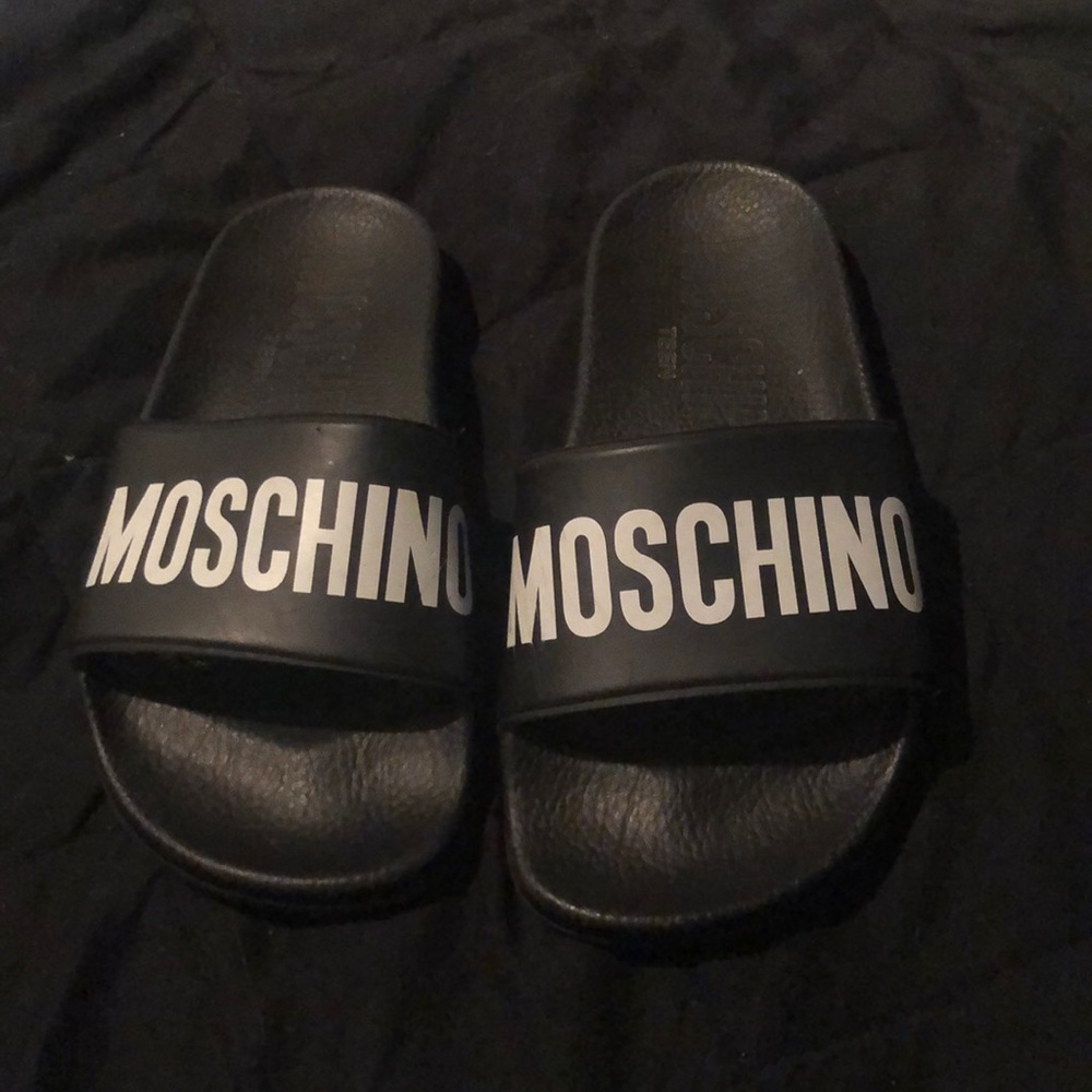 Black Moschino pool slides.